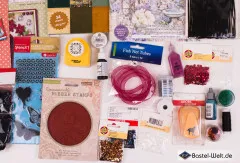 Detailausschnitt mit Kautschukstempel, roten und schwarzen Pailletten, Fisch-Netzband sowie Bastelstanze in Pferdeform.